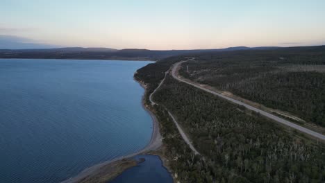 Tolhuin-Fagnano-Cami-Lake-Aerial-Drone-Above-Patagonian-Idyllic-Natural-Forest-and-Pristine-Water,-Border-of-Argentina-and-Chile