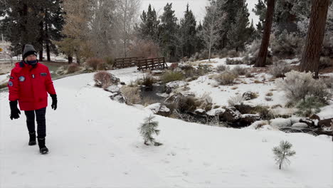 Woman-walking-on-a-trail-in-the-snow-in-winter