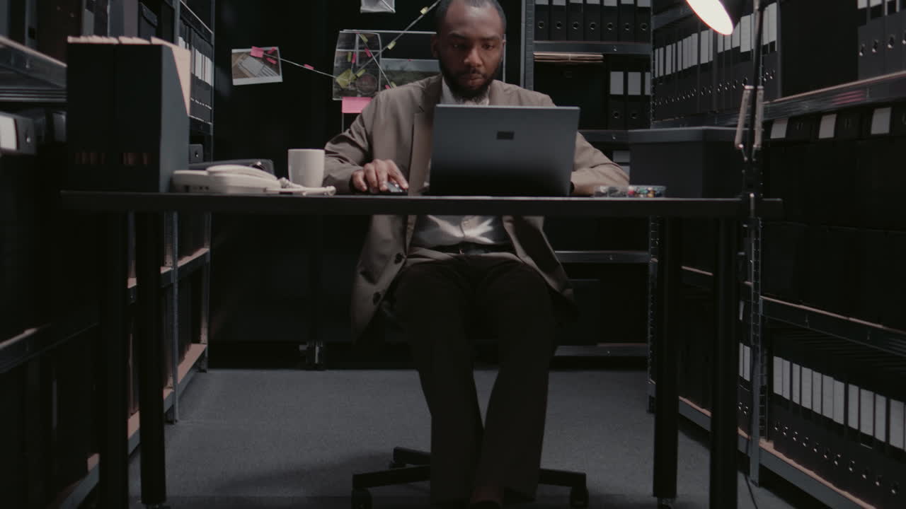 Detective working in office surrounded by evidence