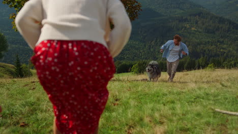 happy family loving husky spending vacation in mountain. man running with dog.