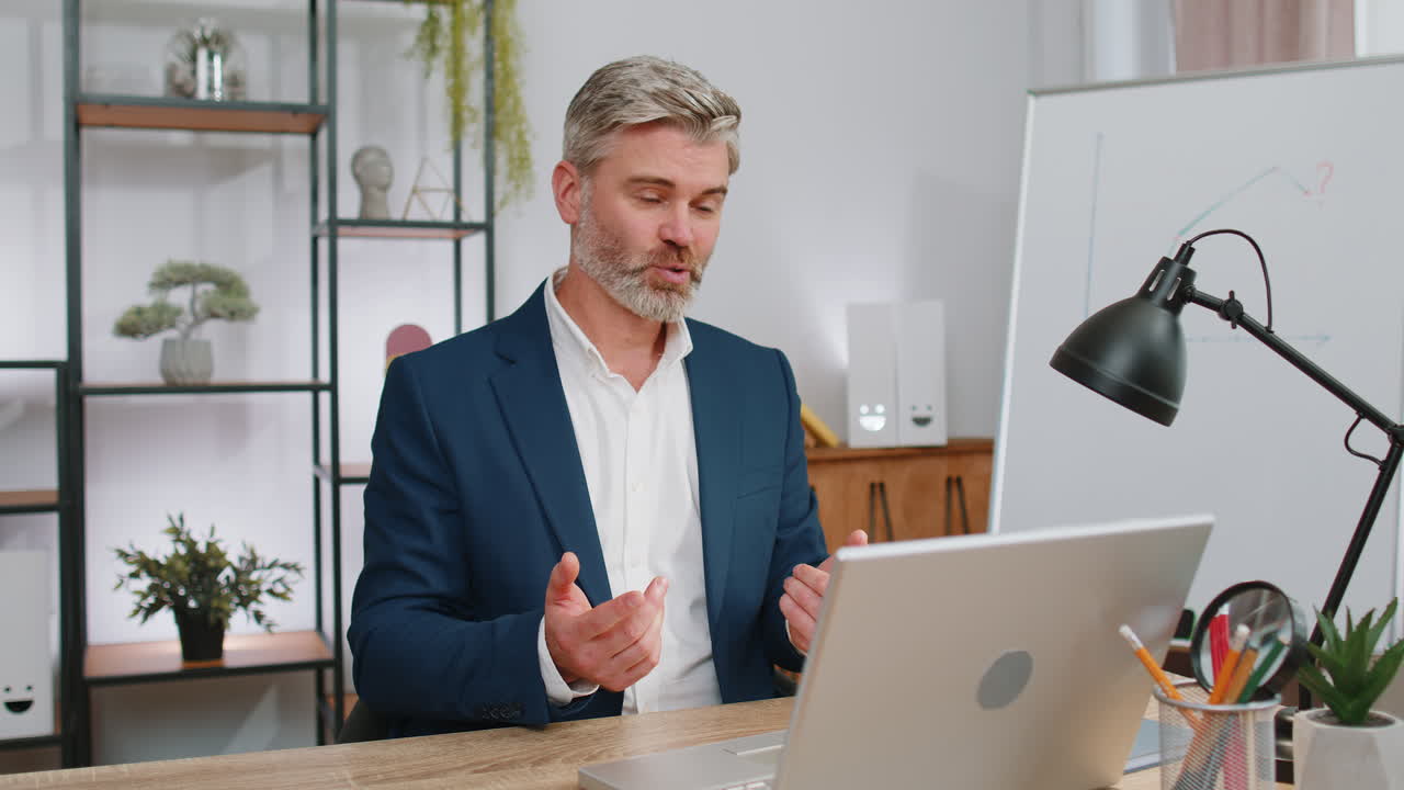 Businessman working on laptop at office talk on online communication video call with employee, boss