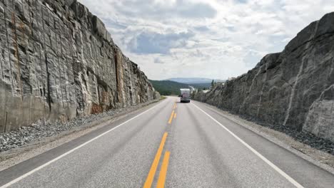 There-is-a-motorhome-travel-RV-with-travelers-on-the-way.-Driving-a-Car-on-a-Road-in-Norway-at-dawn.-Point-of-view-driving.-Family-vacation-travel-RV,-holiday-trip-in-motorhome,-Caravan-car-Vacation.