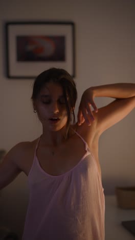 woman stretching in a pink tank top at night