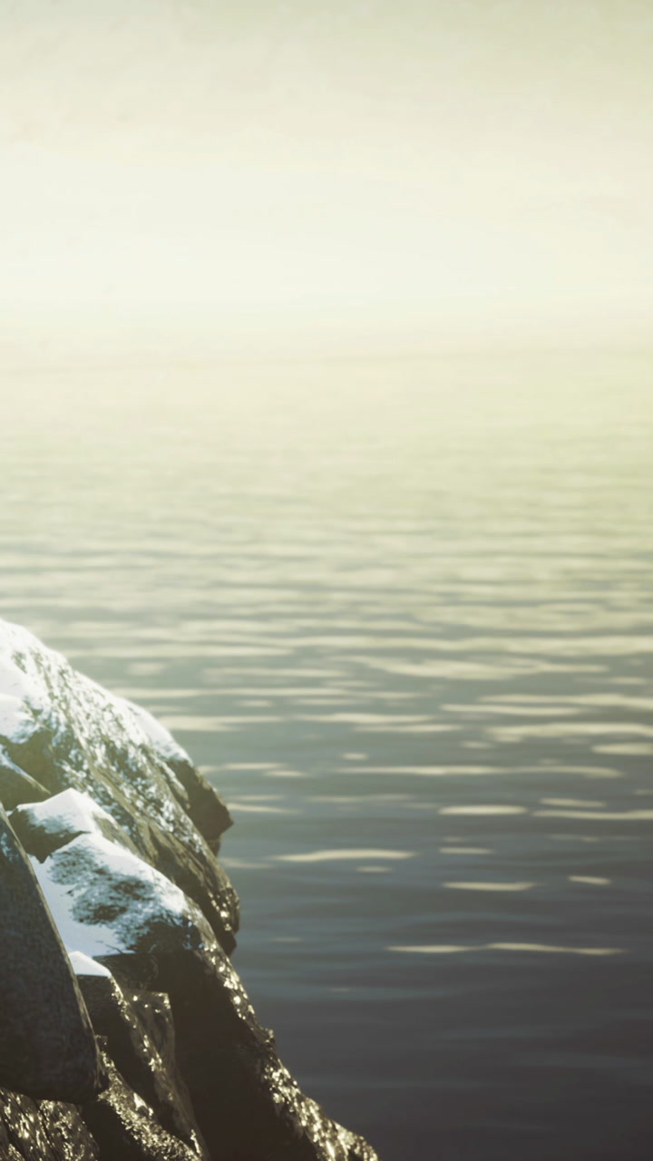 Relaxing view of calm water and rocks at dusk near a lake or ocean