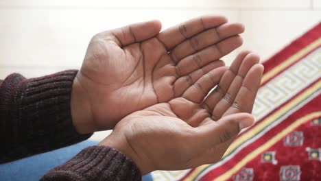 a person praying with their hands raised in prayer.