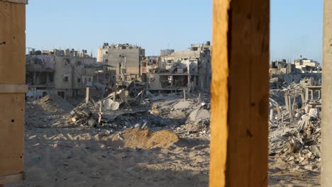 establishing war footage of destroyed buildings in gaza, view through the window