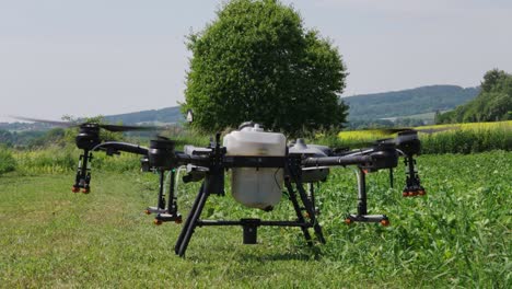 avión no tripulado agrícola con sistema de pulverización prepararse para el despegue desde el campo verde de la granja