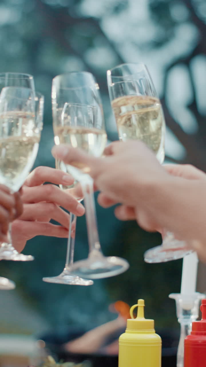 Persone che fanno tintinnare i calici di champagne durante una festa all'aperto