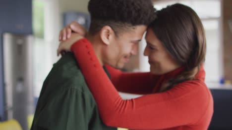 Feliz-Pareja-Birracial-Abrazándose-Y-Sonriendo-Juntos-En-La-Cocina