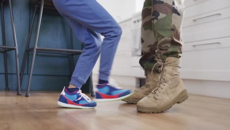 Low-section-of-african-american-father-and-his-son-dancing-togehter-in-kitchen