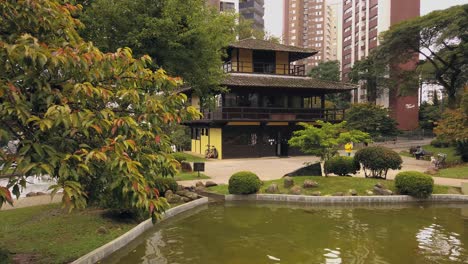 a traditional oriental house amidst an exuberant city, surrounded by lots of trees in a calm and quiet environment, creating a perfect place to relax