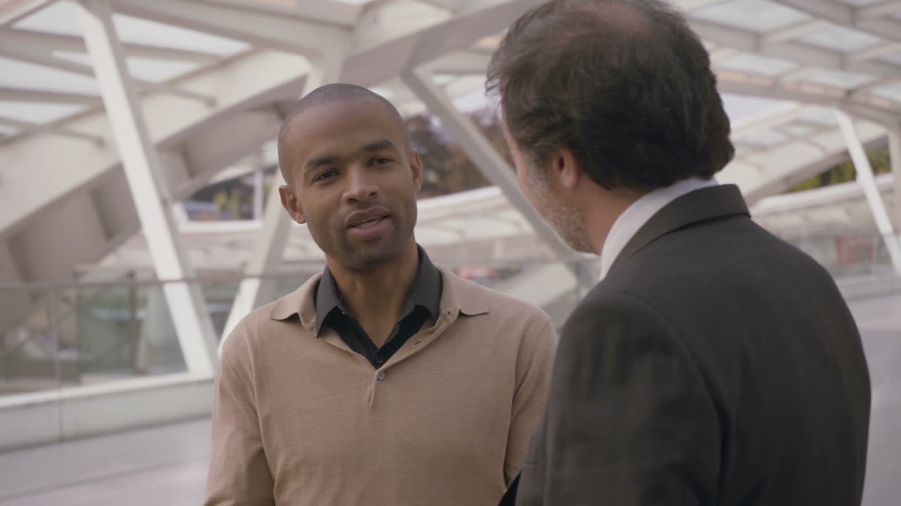 hombre afroamericano teniendo una conversación con un compañero de trabajo en la ciudad