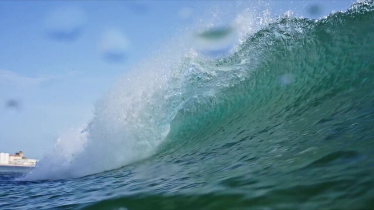 Dynamic water level shot in Tarifa, Spain capturing breaking waves, rolling barrels, white water and crystal clear turquoise Atlantic water with immersive ocean perspective.