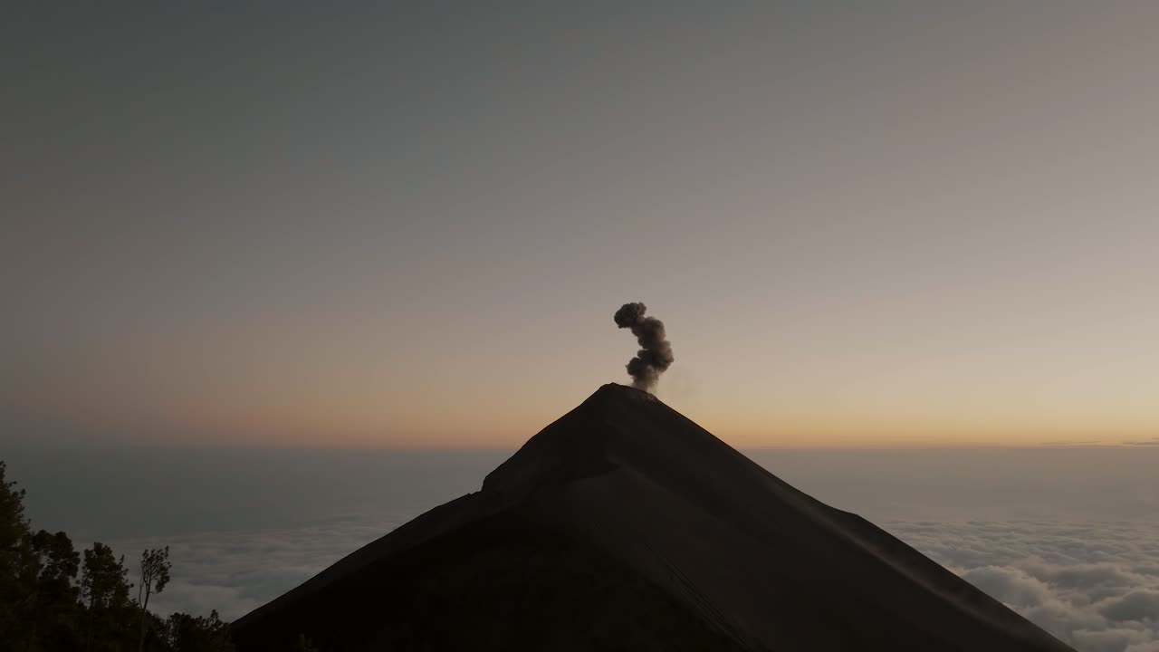 과테말라 에서 해가 뜨는 동안 폭발 하는 화산 의 크레이터 에 연기가  ⁇ 아오르는 공중 사진