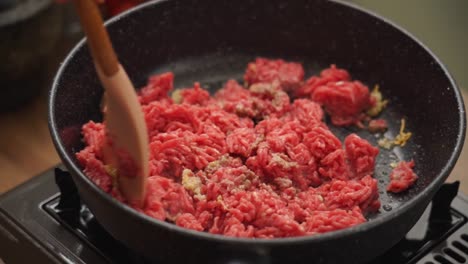 crop cook frying minced meat in pan