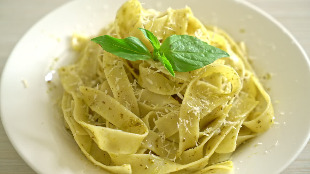 pasta fettuccine al pesto con queso parmesano encima - estilo de comida italiana