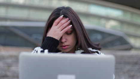 Tired-beautiful-brunette-looking-at-laptop-and-rubbing-face