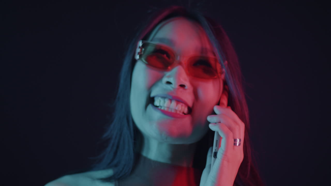 mujer hablando por teléfono con iluminación de neón