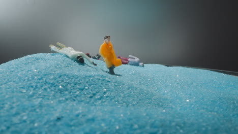 figures of people falling on soft light blue sand after jolt