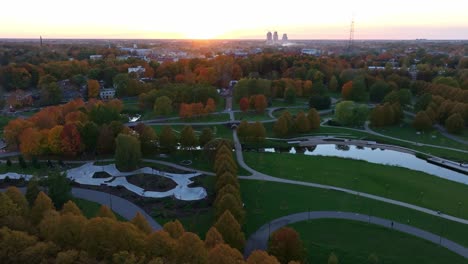 peaceful backward aerial of riga’s renovated victory park during fall sunset