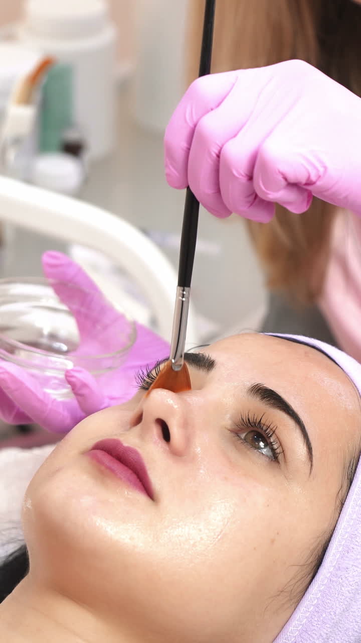 Cleansing peeling in the beauty salon. Cosmetic treatment of face. Aesthetic cosmetology. Vertical video