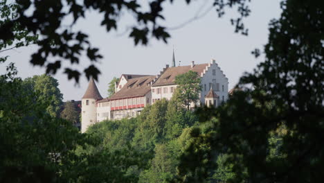 view-of-Laufen-Castle-between-trees-with-leaves,-in-Neuhausen-am-Rheinfall