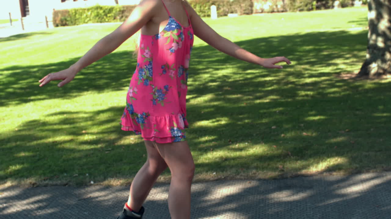 una rubia patinando en el parque.