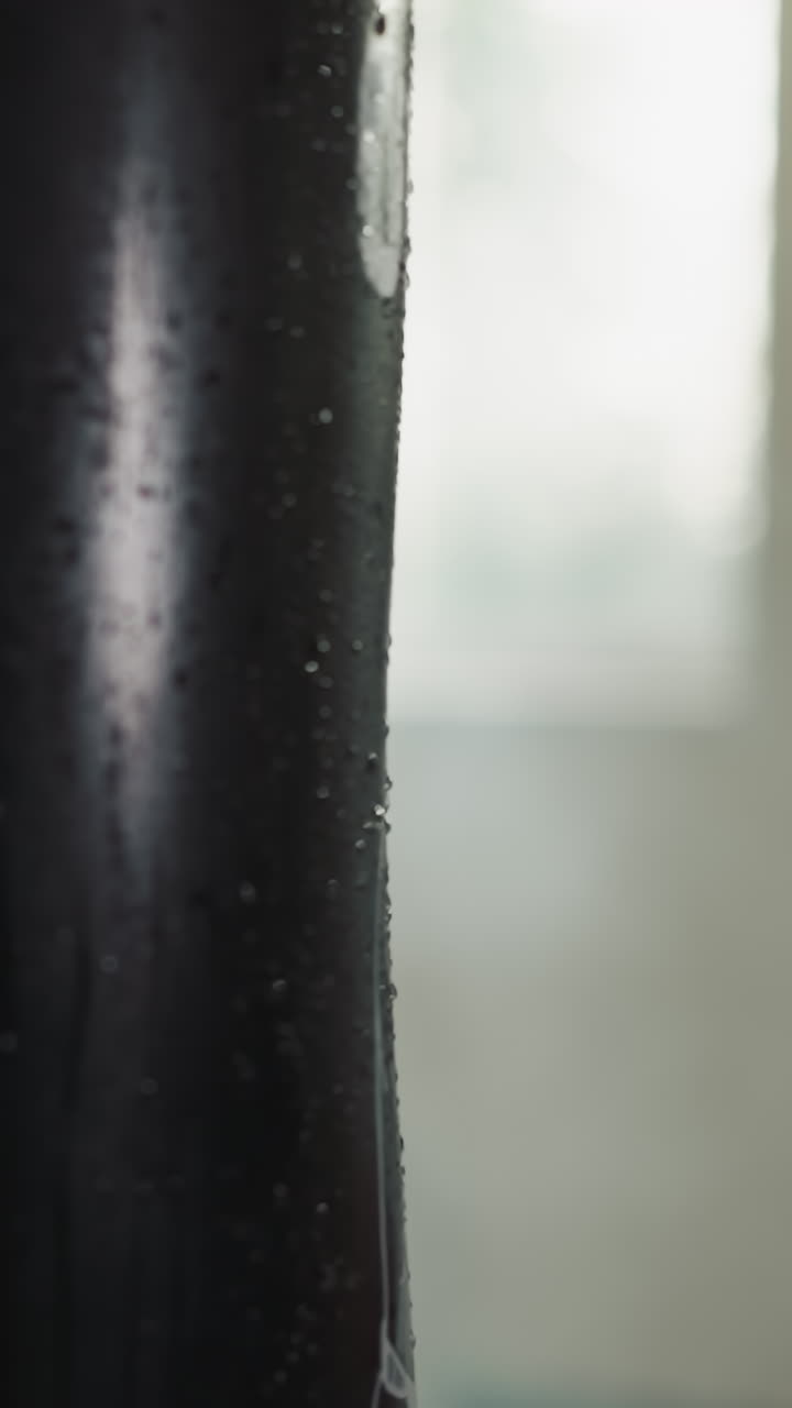 la mano de un atleta fuerte golpea la bolsa de boxeo con fuerza usando un guante de boxeo en un gimnasio oscuro. participando en entrenamiento deportivo profesional en un sótano bien equipado de un club deportivo