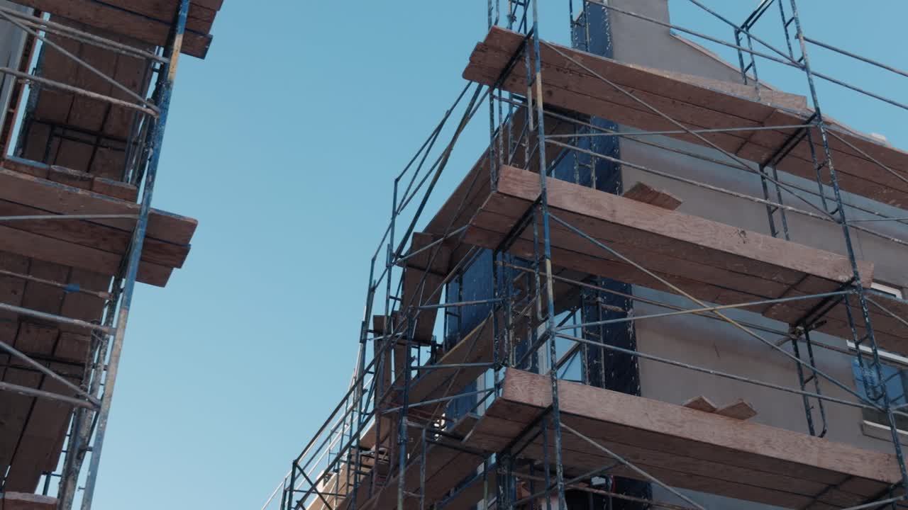 Smooth exterior pan of scaffolded multi story housing under construction