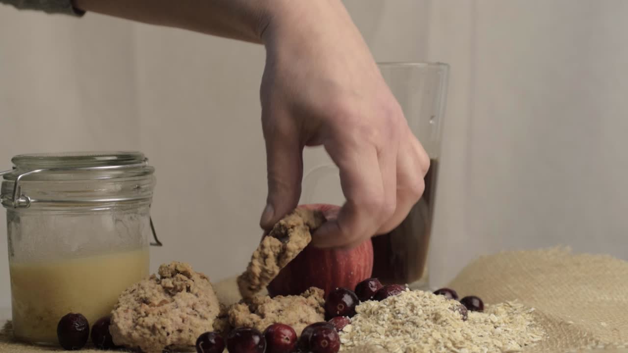 Hand reaching for homemade cookie to dunk in pot of coffee medium shot