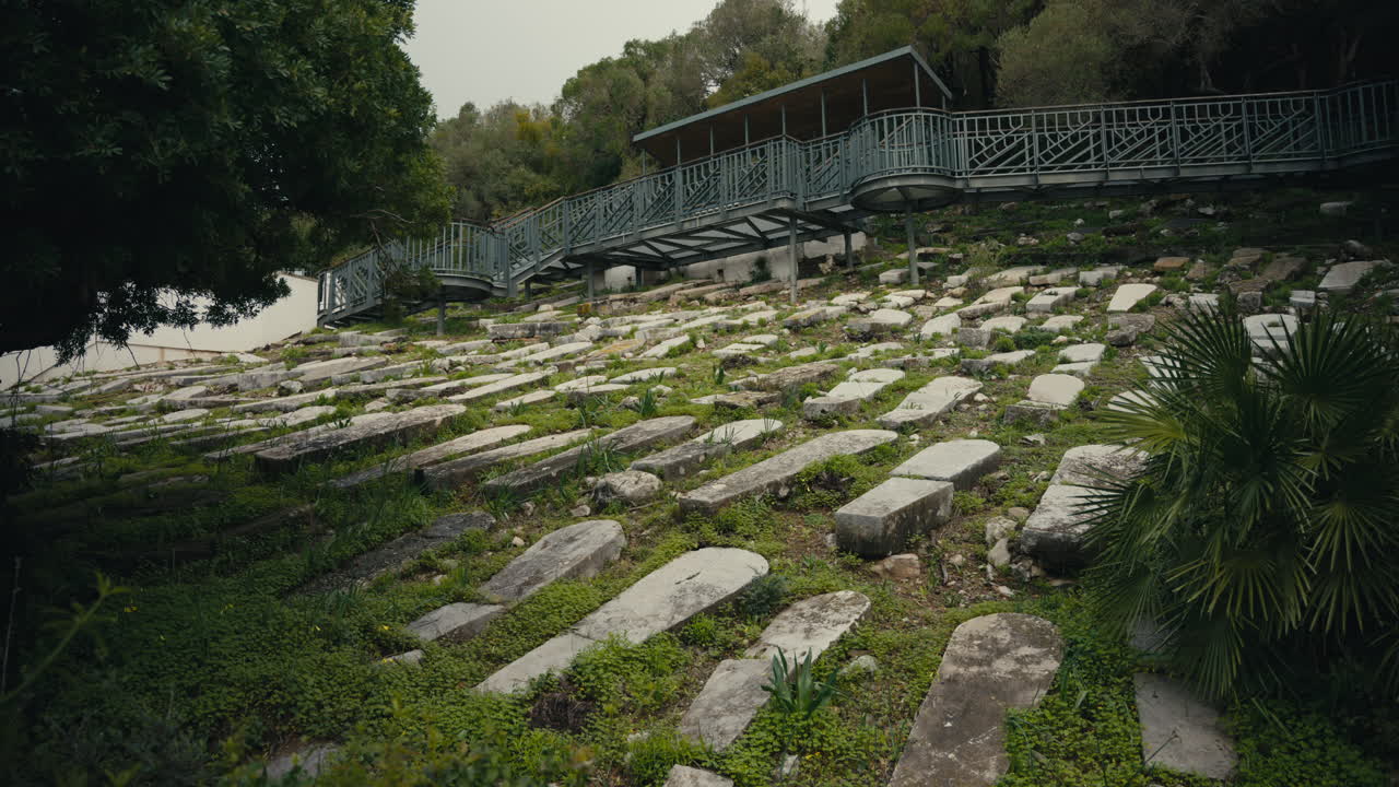 Storico cimitero ebraico sulla Rocca di Gibilterra, con file di vecchie lapidi in pietra su un pendio sotto una moderna passerella