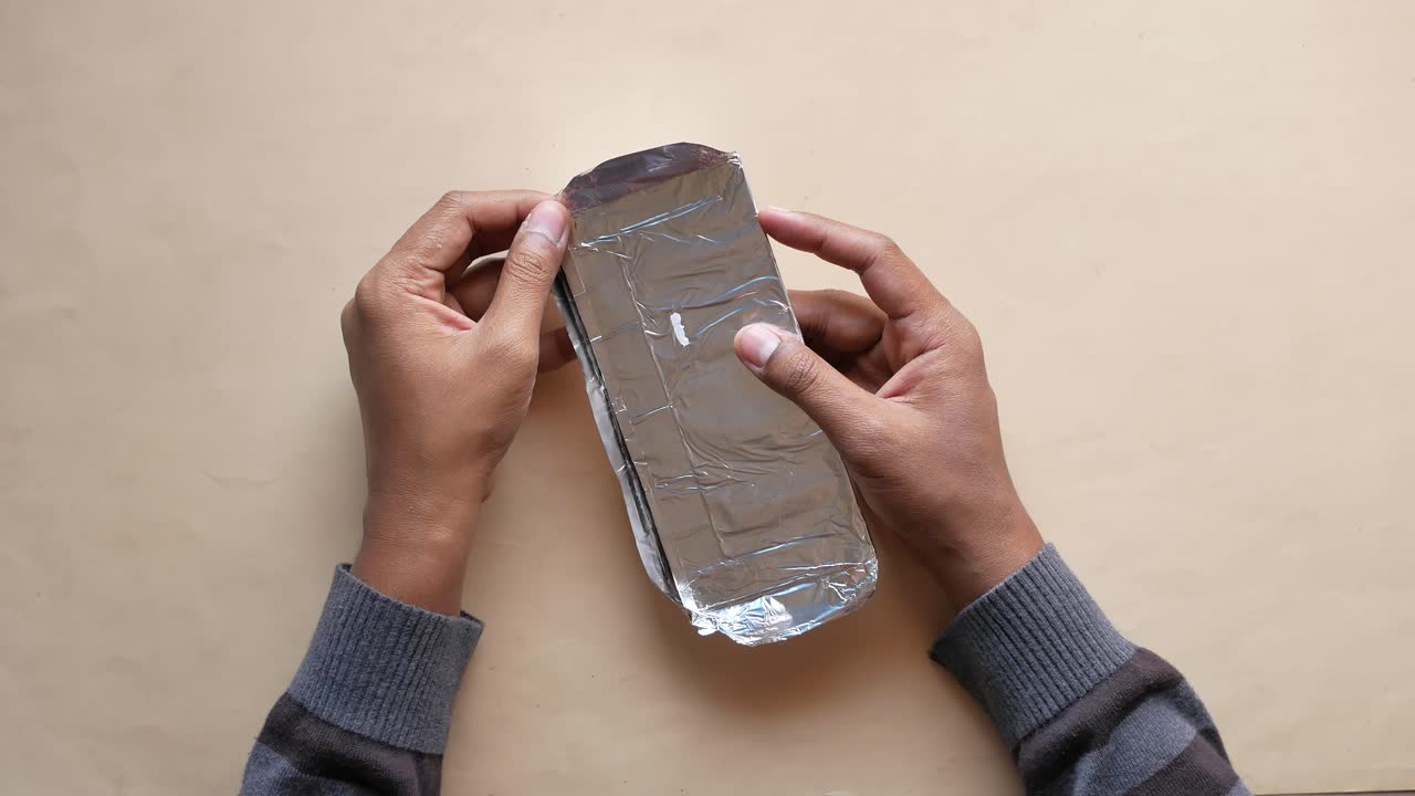 manos sosteniendo una barra de chocolate sin envolver