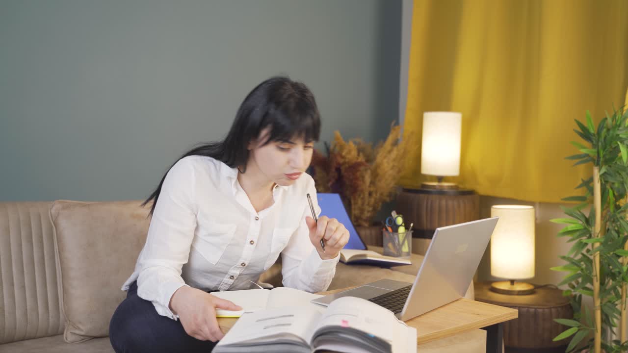 estudiante masculino estudiando por la noche en la luz de la computadora portátil.