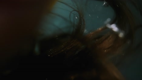 underwater shot of a person breaking through the surface with bubbles and dramatic lighting