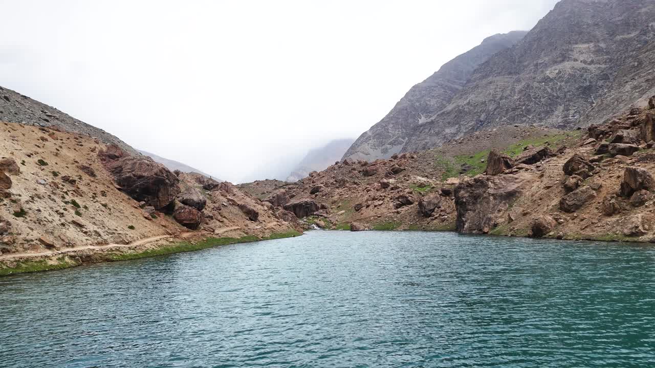 Aerial drone shot of Depak Tal reflecting the sky and surrounding mountains in its calm surface.