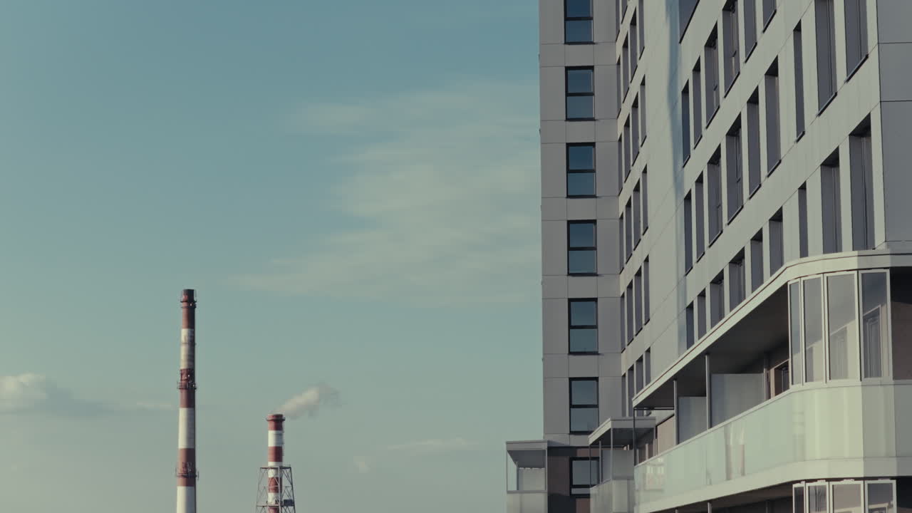 Modern Apartment Building and Industrial Chimney