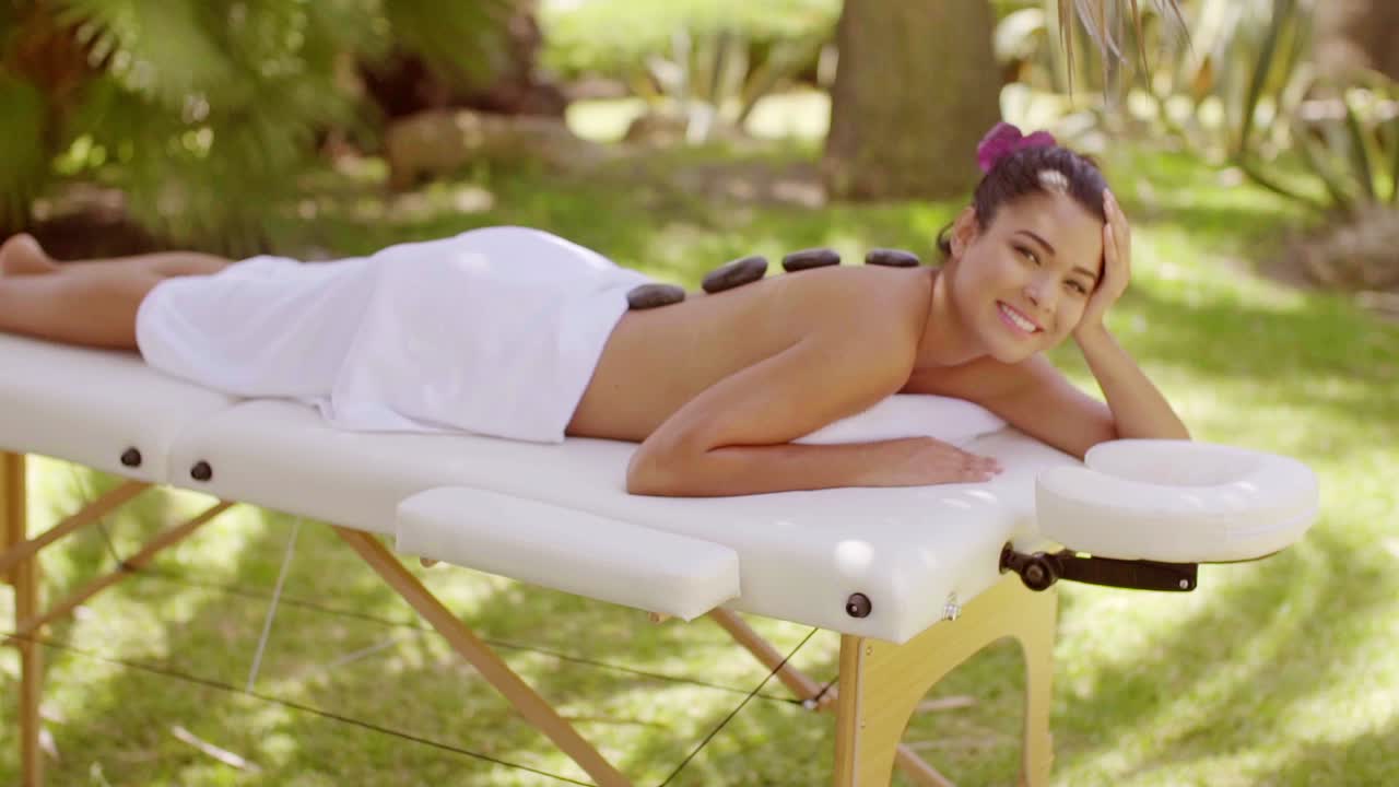 뜨거운 돌 마사지를 하는 예쁜 젊은 여자