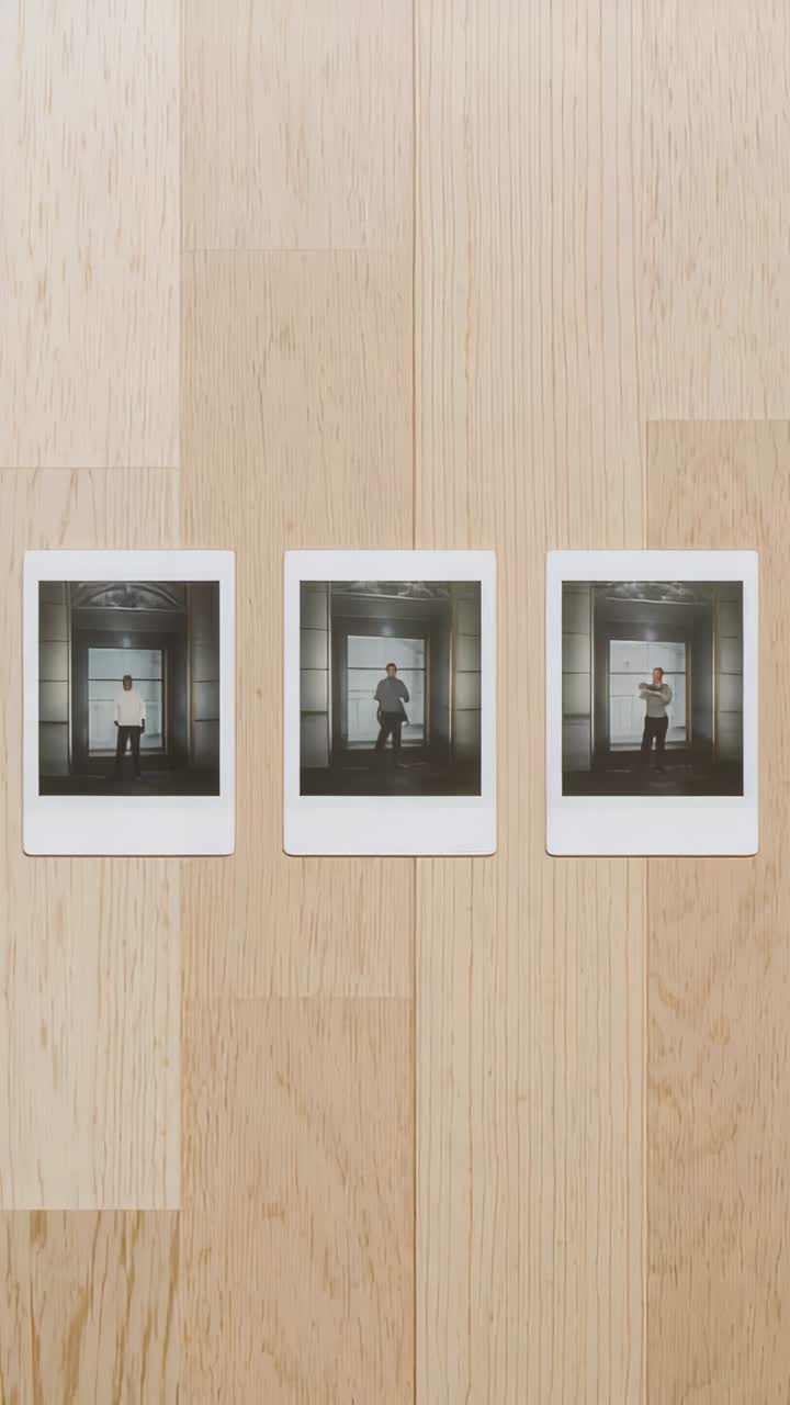 Vertical video: Showing polaroids forming 3x3 grid on wood table, man posing in pale shirt