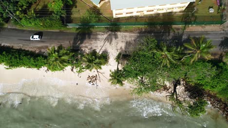 Drohnenaufnahme-Von-Klimawandel,-Globaler-Erwärmung,-Flut,-Anstieg-Des-Meeresspiegels-Bis-Zur-Hauptstraße,-Vorbeifahrende-Autos-über-Sand,-Strand-Anse-Royale,-Mahe,-Seychellen-30fps