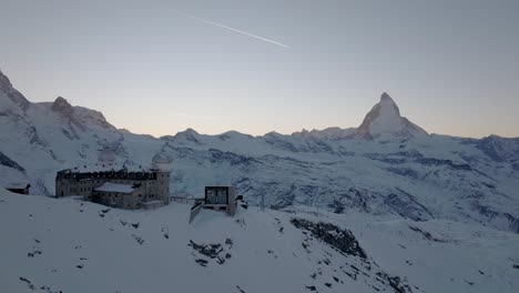 el observatorio de gornergrat y el impresionante panorama montañoso de matterhorn durante la puesta de sol con un avión volando sobre los hermosos alpes suizos épicos