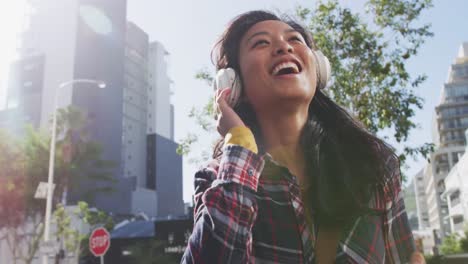 mixed race woman listening music on the street