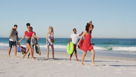 young adult friends on holiday walking on a beach 4k