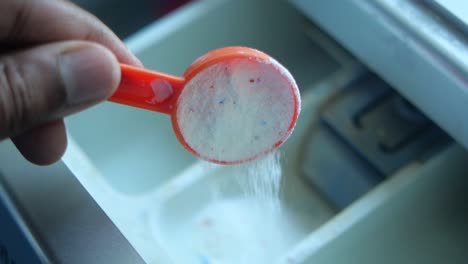 adding laundry detergent to washing machine