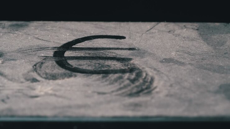 Finger Drawing of a Euro on a Very Dusty Table