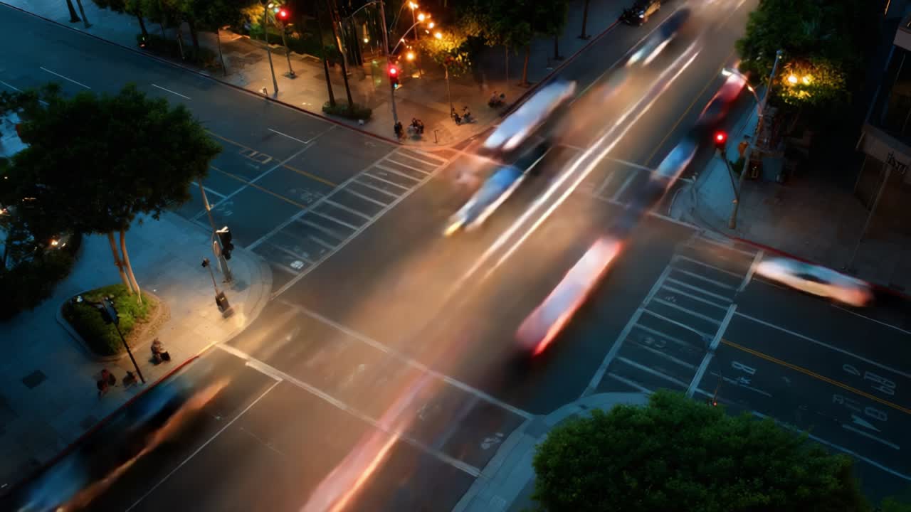 Dynamic Urban Intersection at Night: A Stunning View of Traffic Flowing Through Busy City Streets Illuminated by Vibrant Streetlights, Showcasing the Movement of Vehicles and Pedestrians in a Lively Metropolis