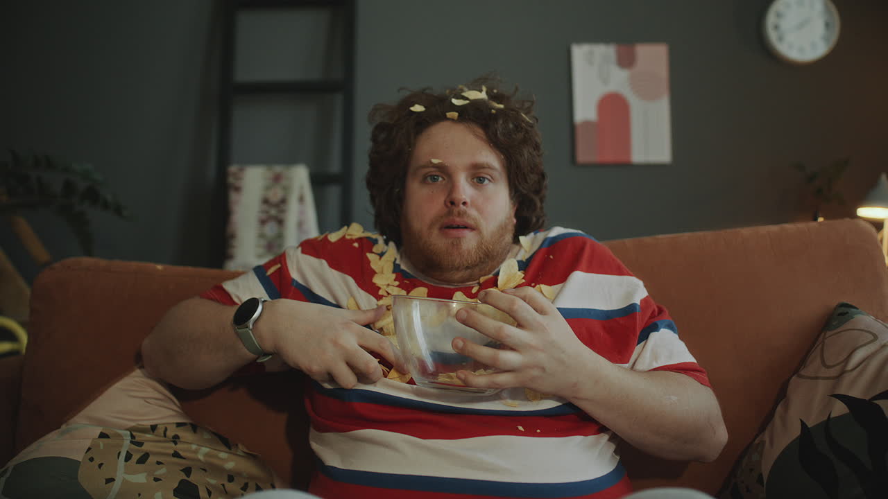 Man Eating Chips While Watching TV
