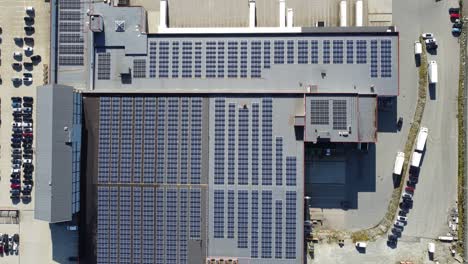 Thousands-of-solar-panels-installed-on-rooftop-of-Asko-company-warehouse-in-Arna-Norway---Birdseye-aerial-moving-slowly-left-above-solar-panels