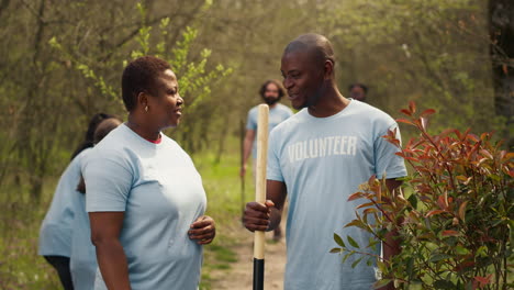 portrait of couple volunteering to plant trees and collect trash from the woods