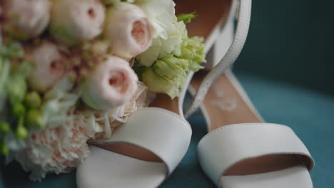 White-peep-toe-shoes-and-wedding-bouquet-on-blue-table