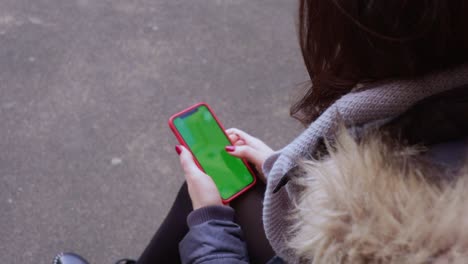 woman using phone green screen outdoors